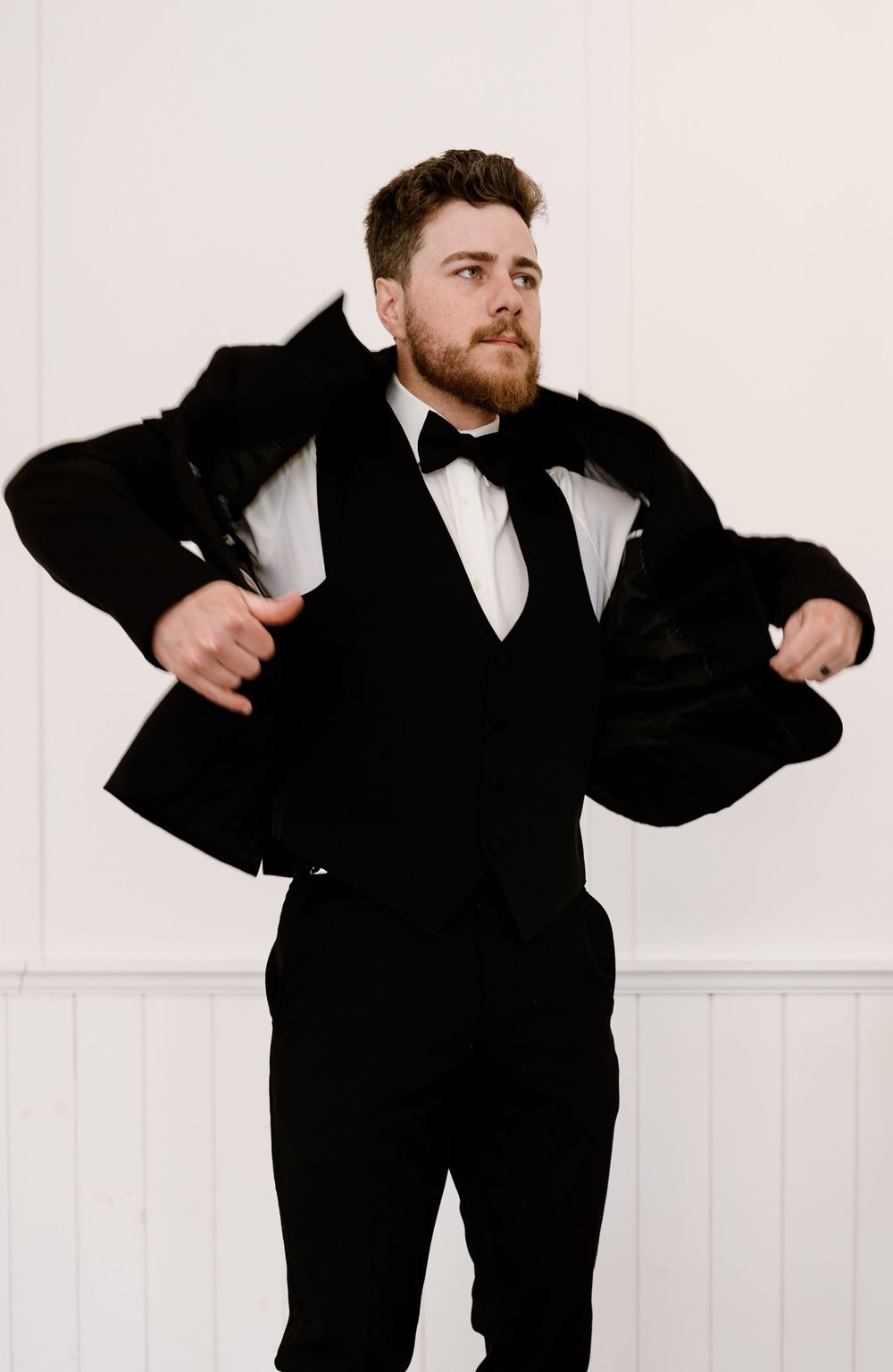 A series of dynamic poses in a black tuxedo against a white backdrop showing playful movement and energy.