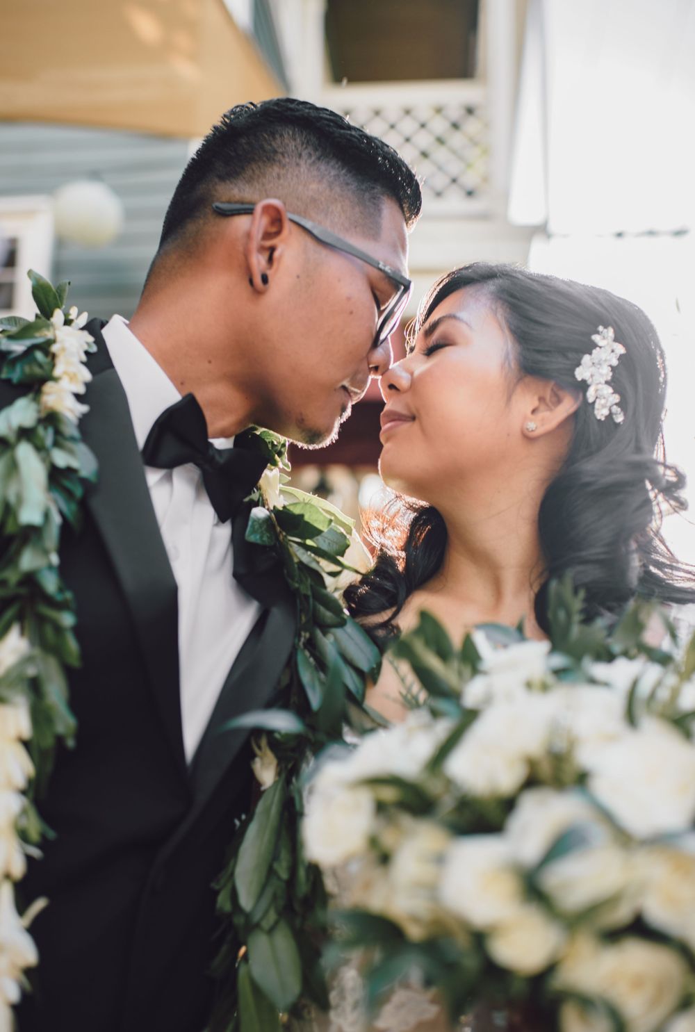 Romantic wedding portrait with greenery and white floral decorations.