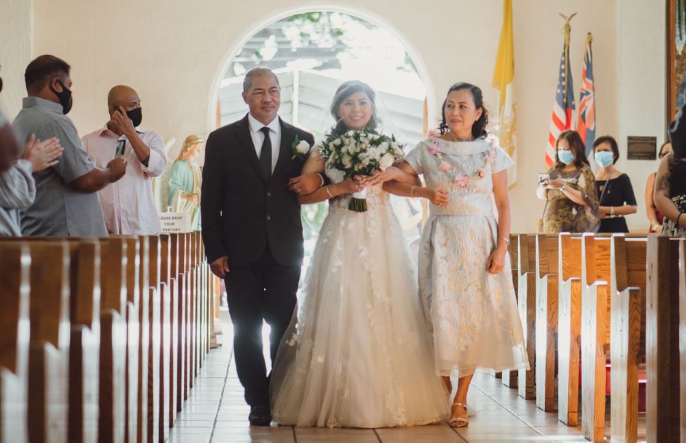 Wedding ceremony procession in traditional church with white floral decorations.