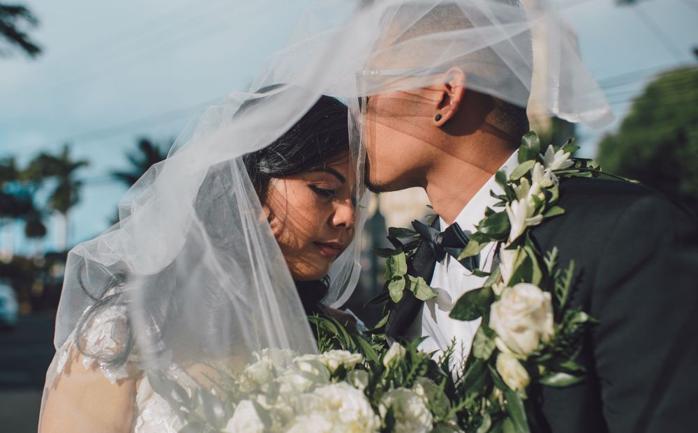 Tender wedding moment captured with soft natural lighting and white flowers.