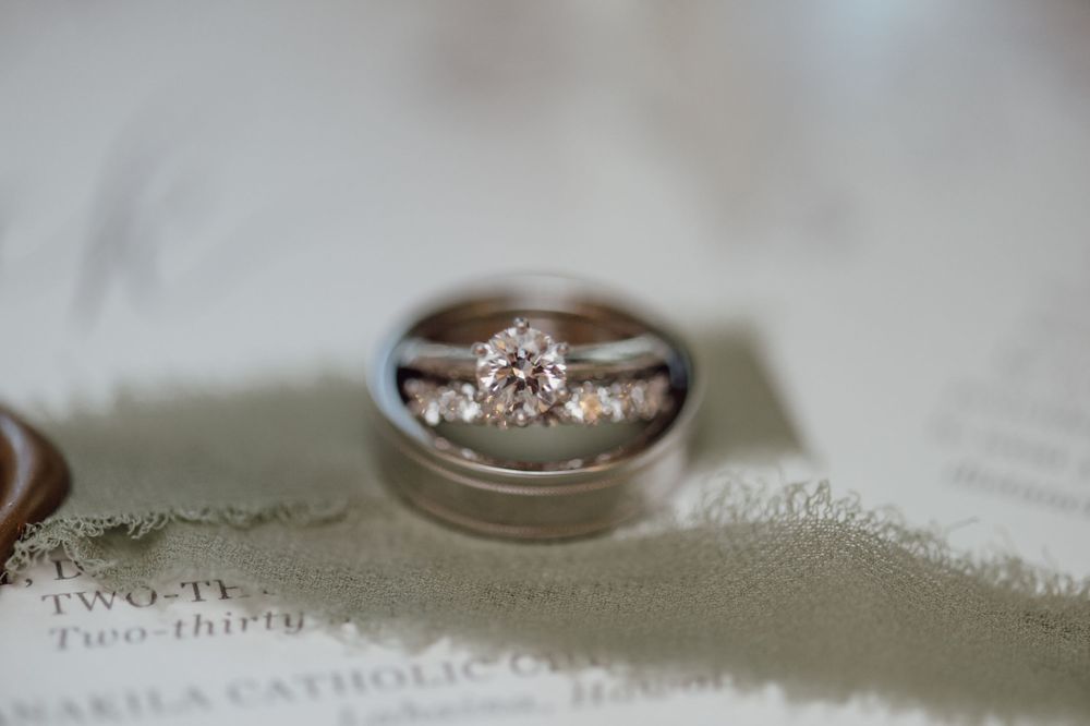 Macro shot of elegant diamond wedding rings on textured fabric.