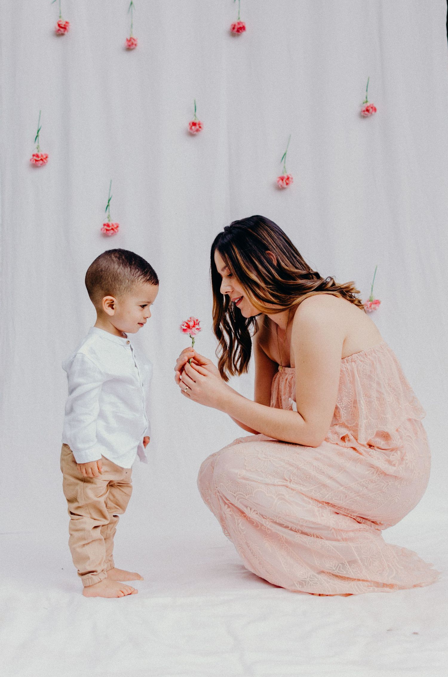 Sweet moment with hanging red flowers in background.