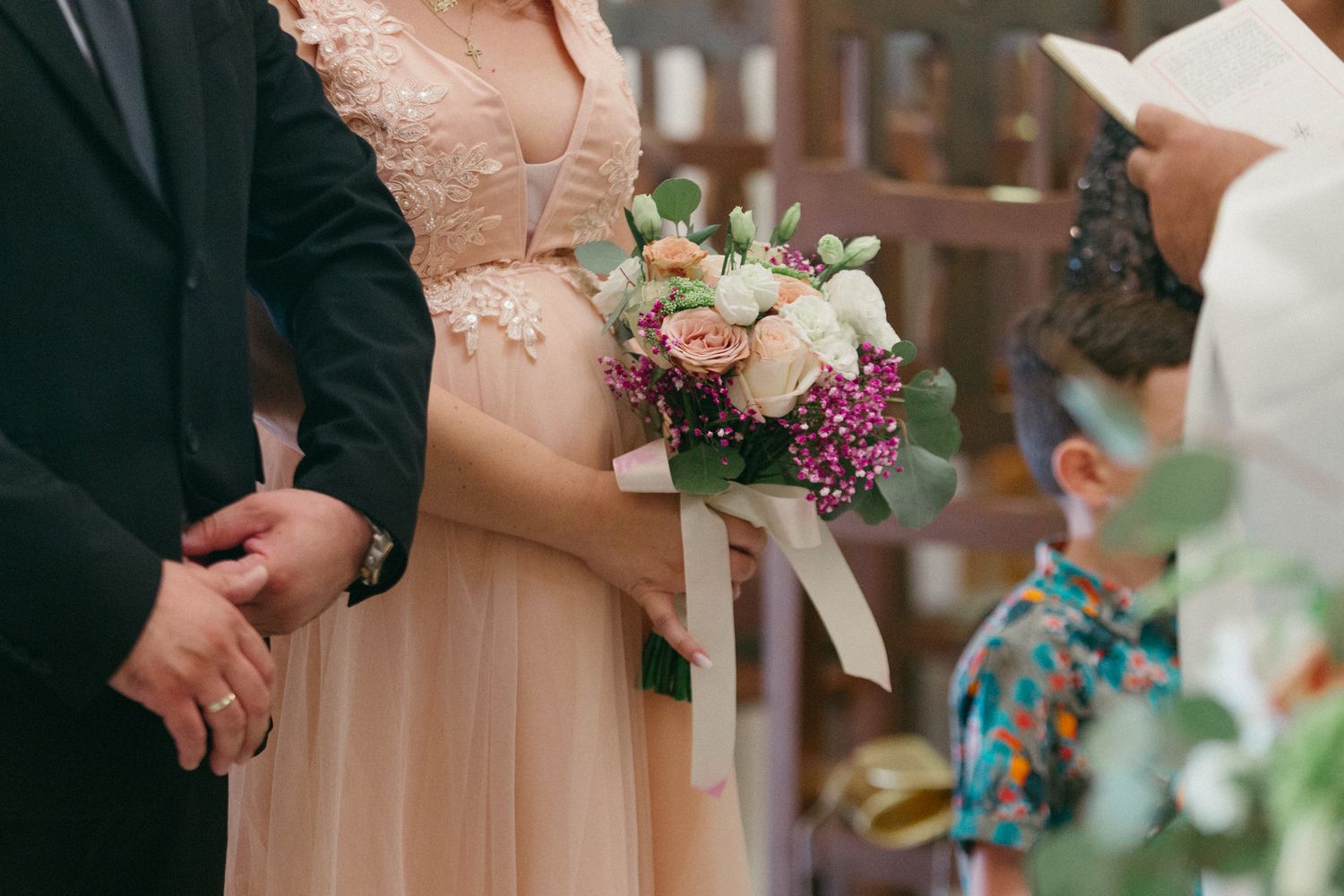 A series of wedding ceremony photos showing hands exchanging rings and holding bouquets in an indoor venue.