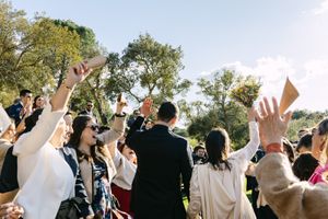 A panoramic view of wedding guests raising their hands in celebration during a wedding ceremony in Lisbon.