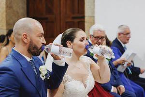 Groom and bride drinking water from a bottle during wedding ceremony in Lisbon