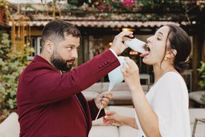 A couple eating cotton candy during their wedding celebration in Lisbon