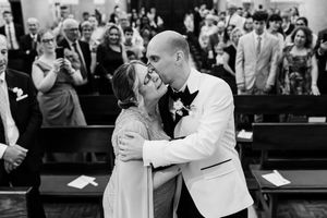 Black and white groom and mother entrance on a catholic church