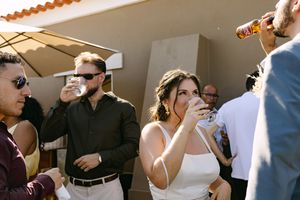 A group of people in formal attire enjoying drinks and socializing at an outdoor wedding in Lisbon