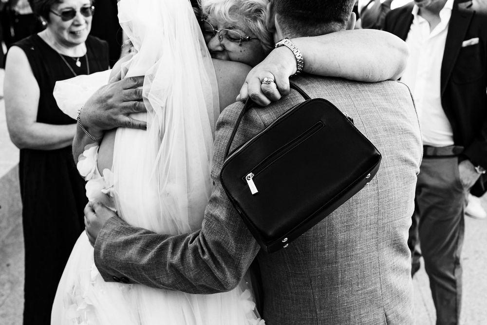 A couple being hugged by their grandmother after a wedding ceremony in Lisbon