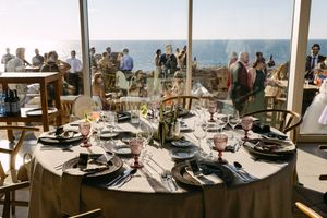 Panoramic view of a beachfront wedding venue with outdoor dining tables and chairs overlooking the ocean in Lisbon