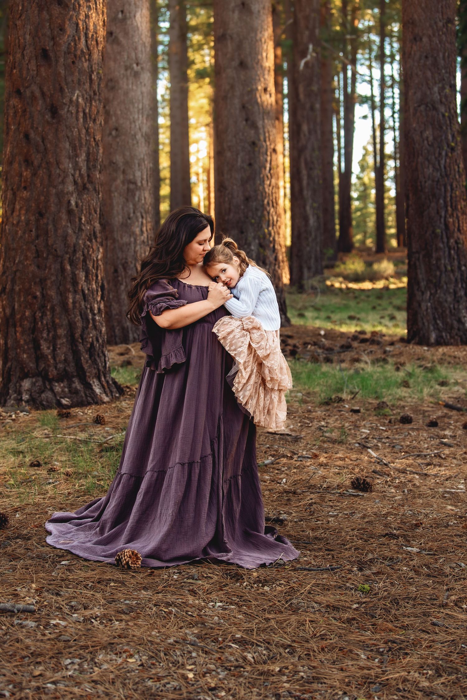 A series of intimate forest portraits showing tender embraces between figures wearing a flowing purple dress among tall pine trees.