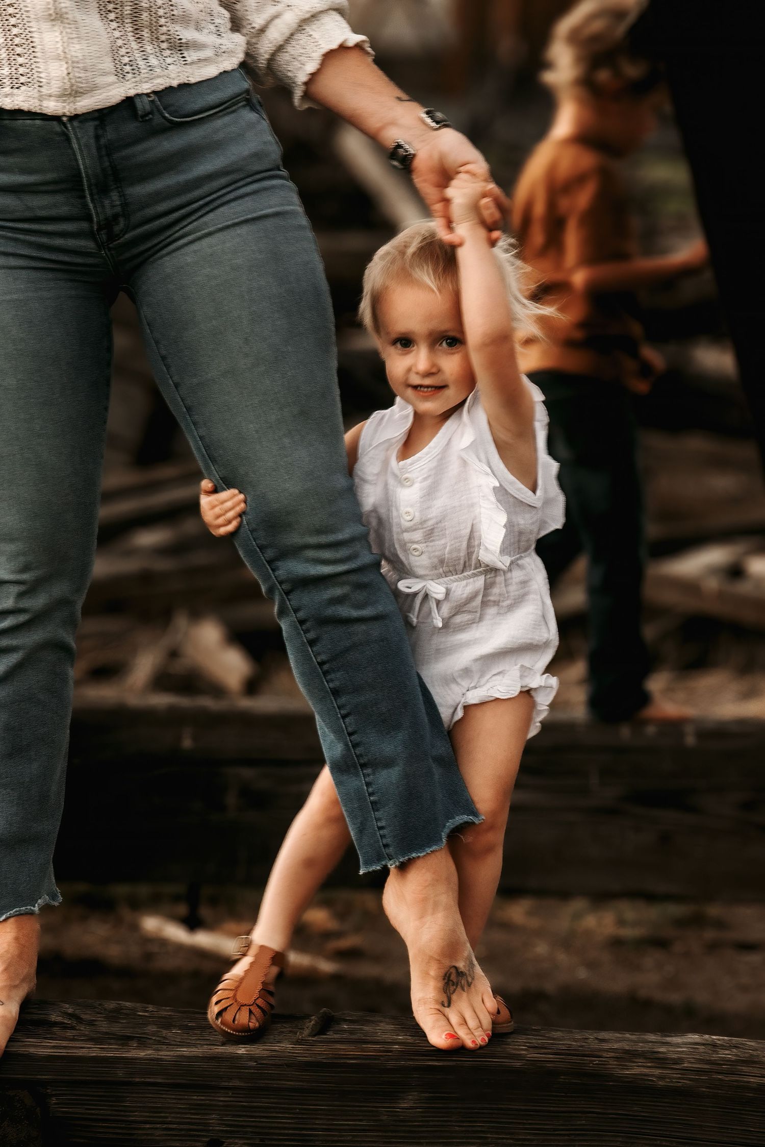 A series of photos showing bare feet and small sandaled feet walking together on dark wooden planks.