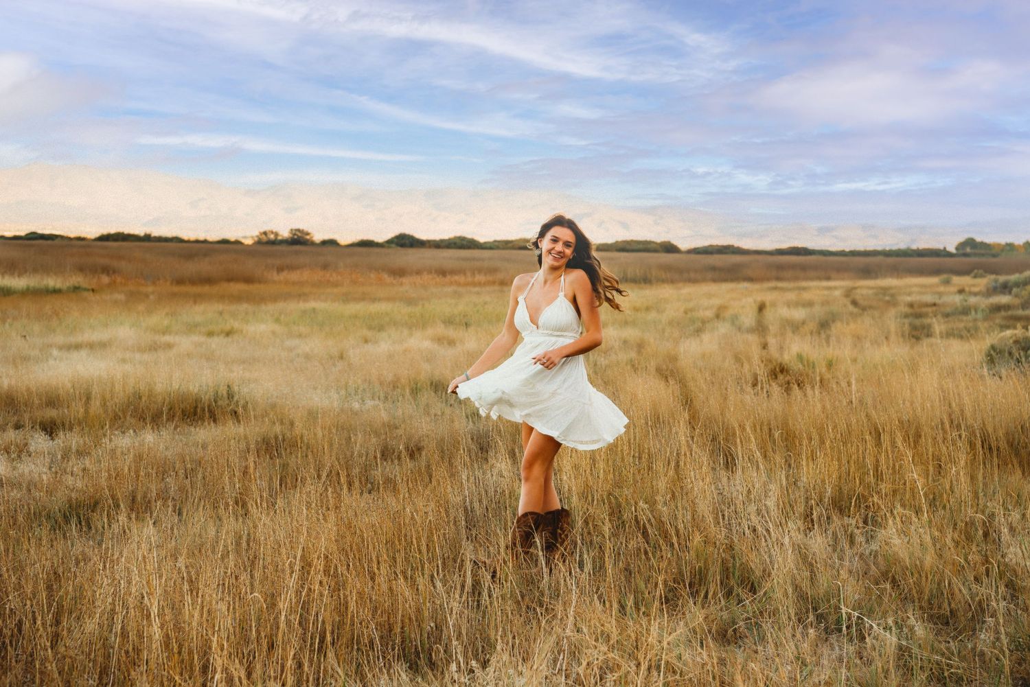 A flowing white dress twirls gracefully in a golden autumn field.