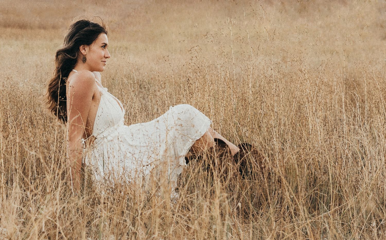 A white dress contrasts beautifully against golden wheat fields in this artistic portrait.