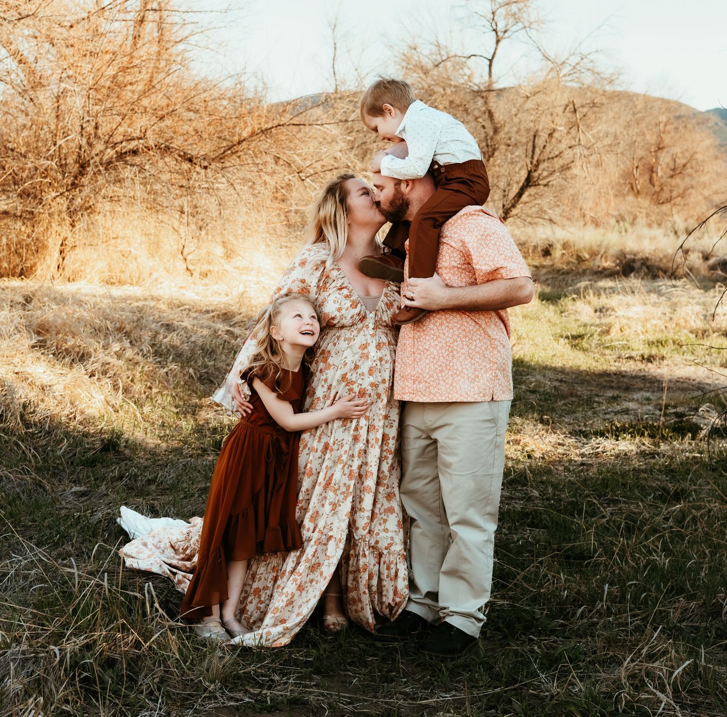 Family portrait in natural setting with warm autumn colors.
