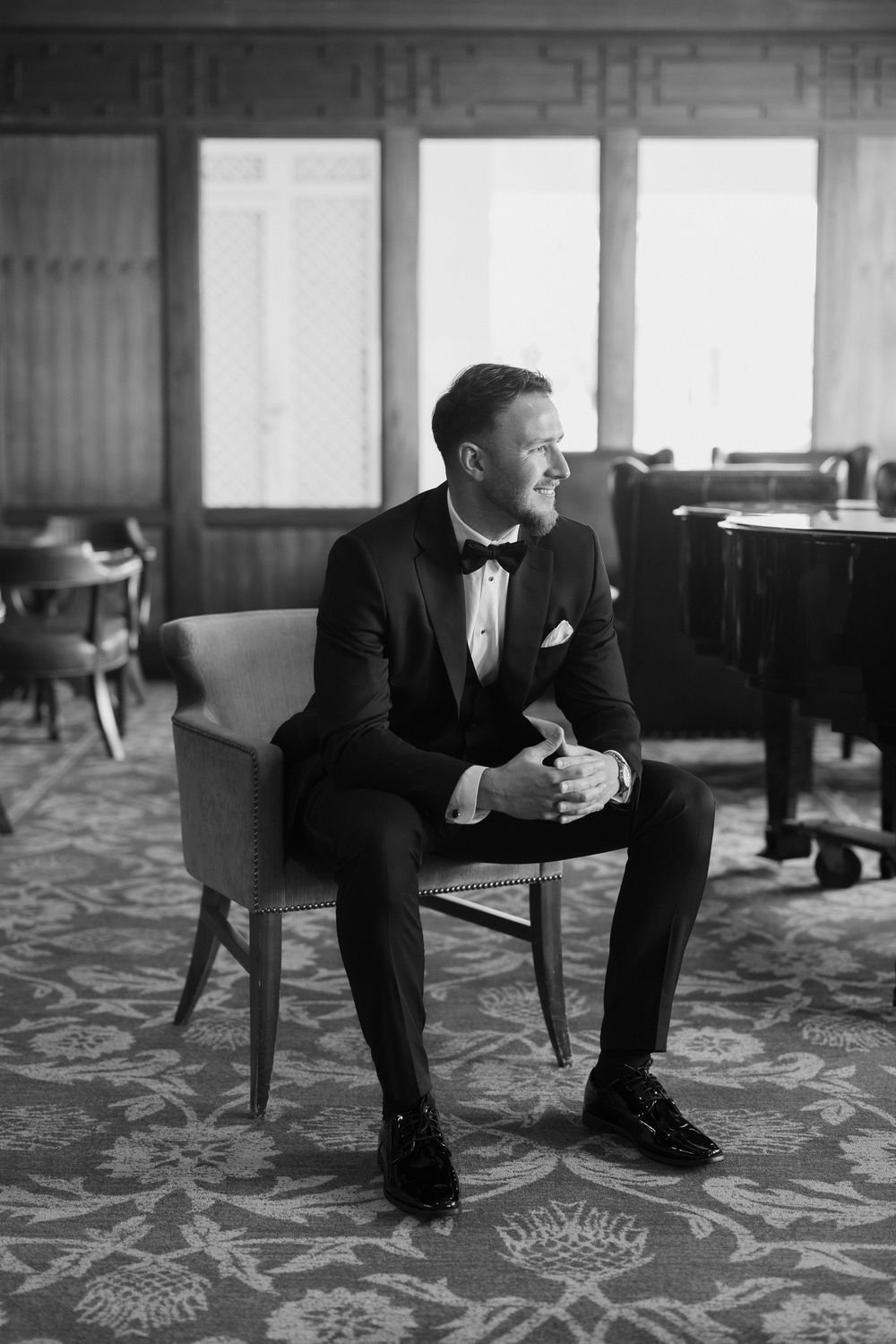 A black and white photo sequence shows a person in a suit sitting contemplatively on a patterned carpet floor.