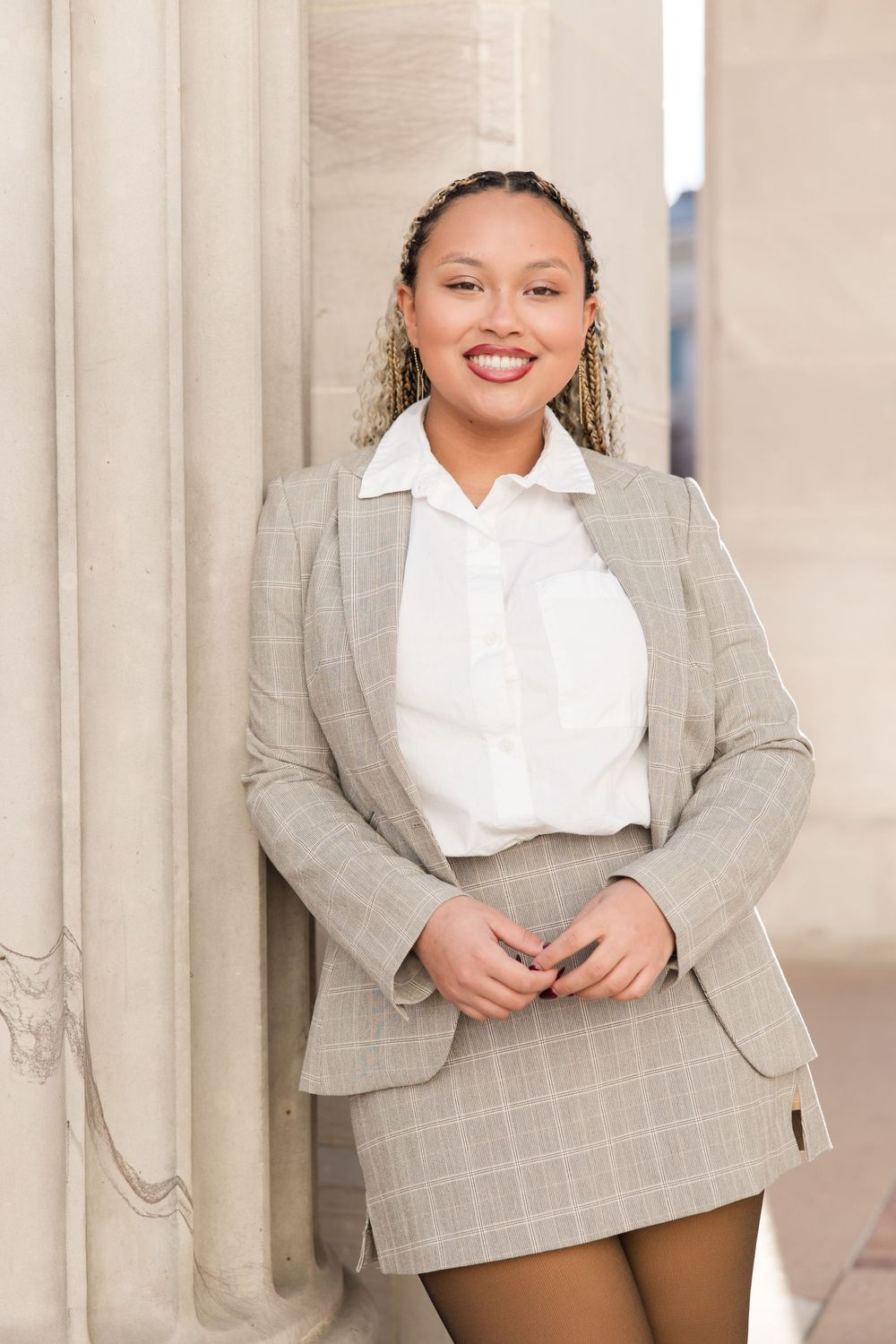 Professional portrait photos showing a stylish outfit combination of a white blouse and gray plaid blazer.