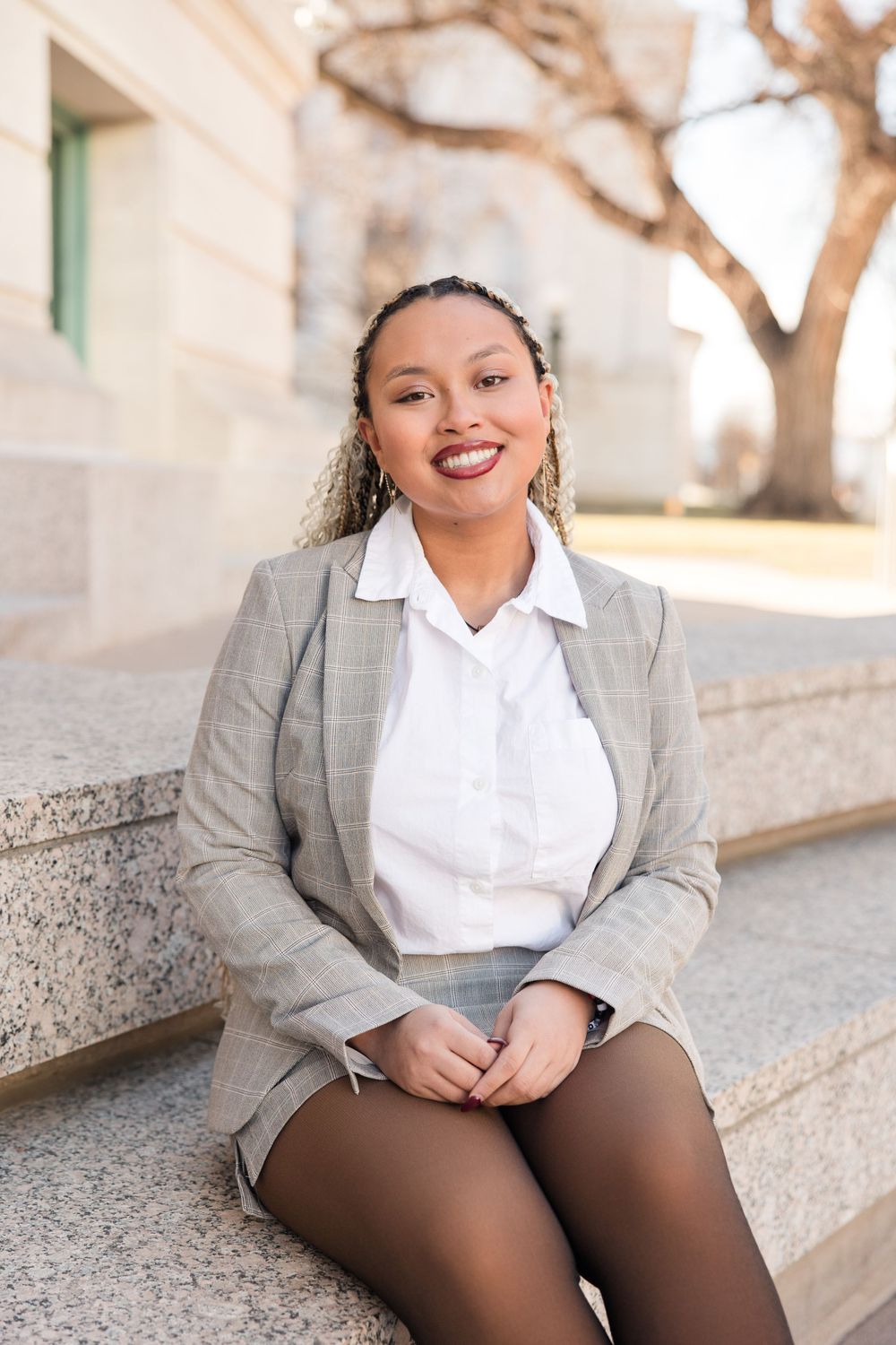 Outdoor fashion photography featuring a business outfit with gray blazer and brown tights.