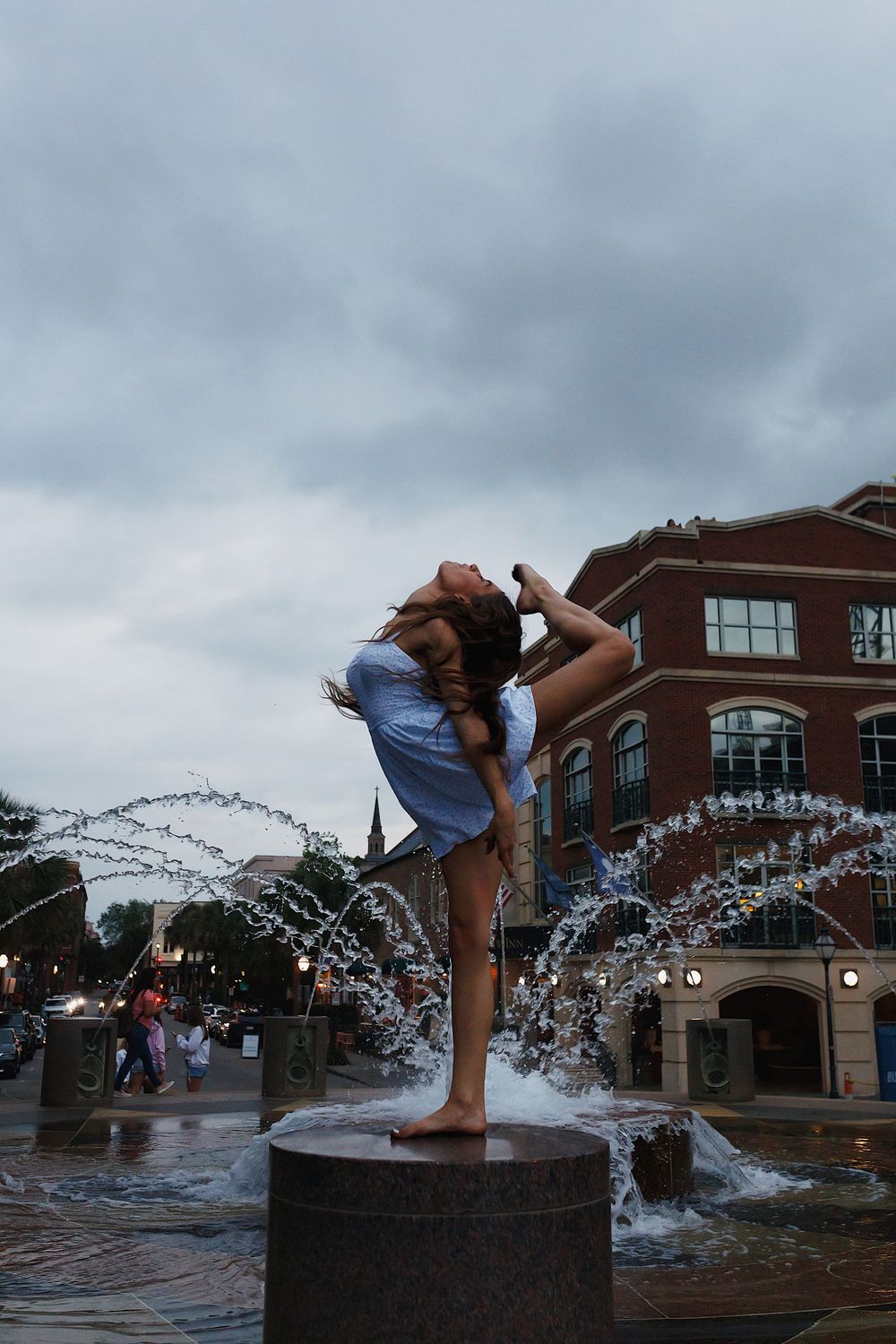 A sequence of photos shows a person doing a high kick move in a fountain, creating dramatic water splashes against a cloudy sky.