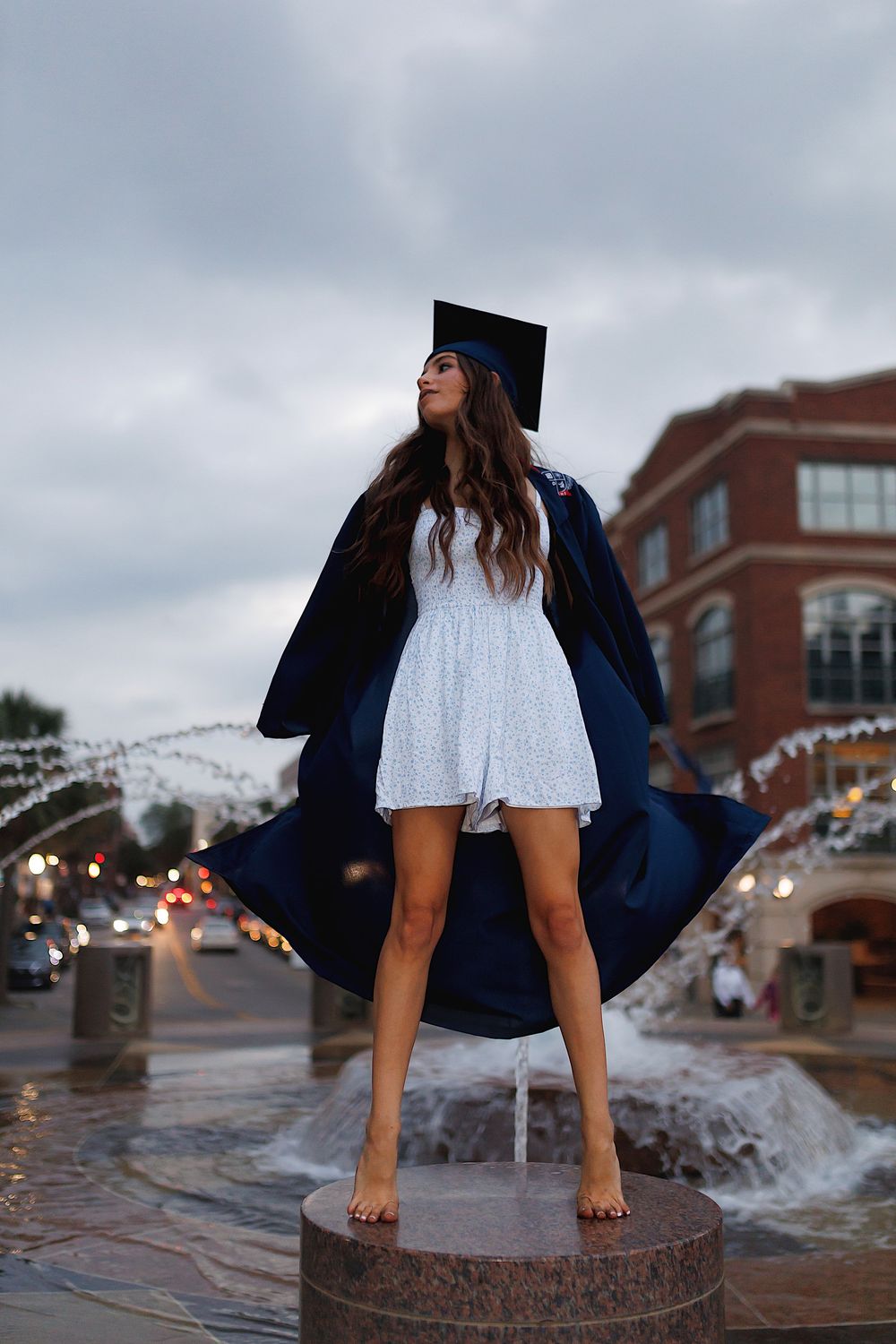 A series of artistic photos showing bare feet splashing in urban water fountains while wearing a navy jacket and white dress.