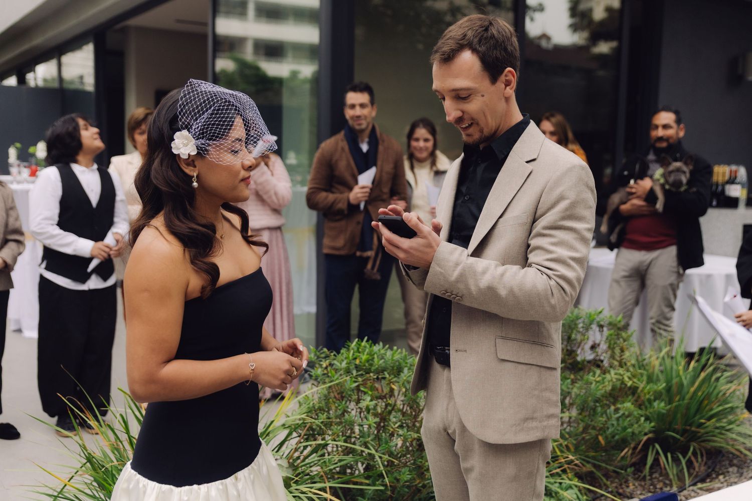 Groom reads vows to smiling bride during intimate outdoor wedding ceremony.
