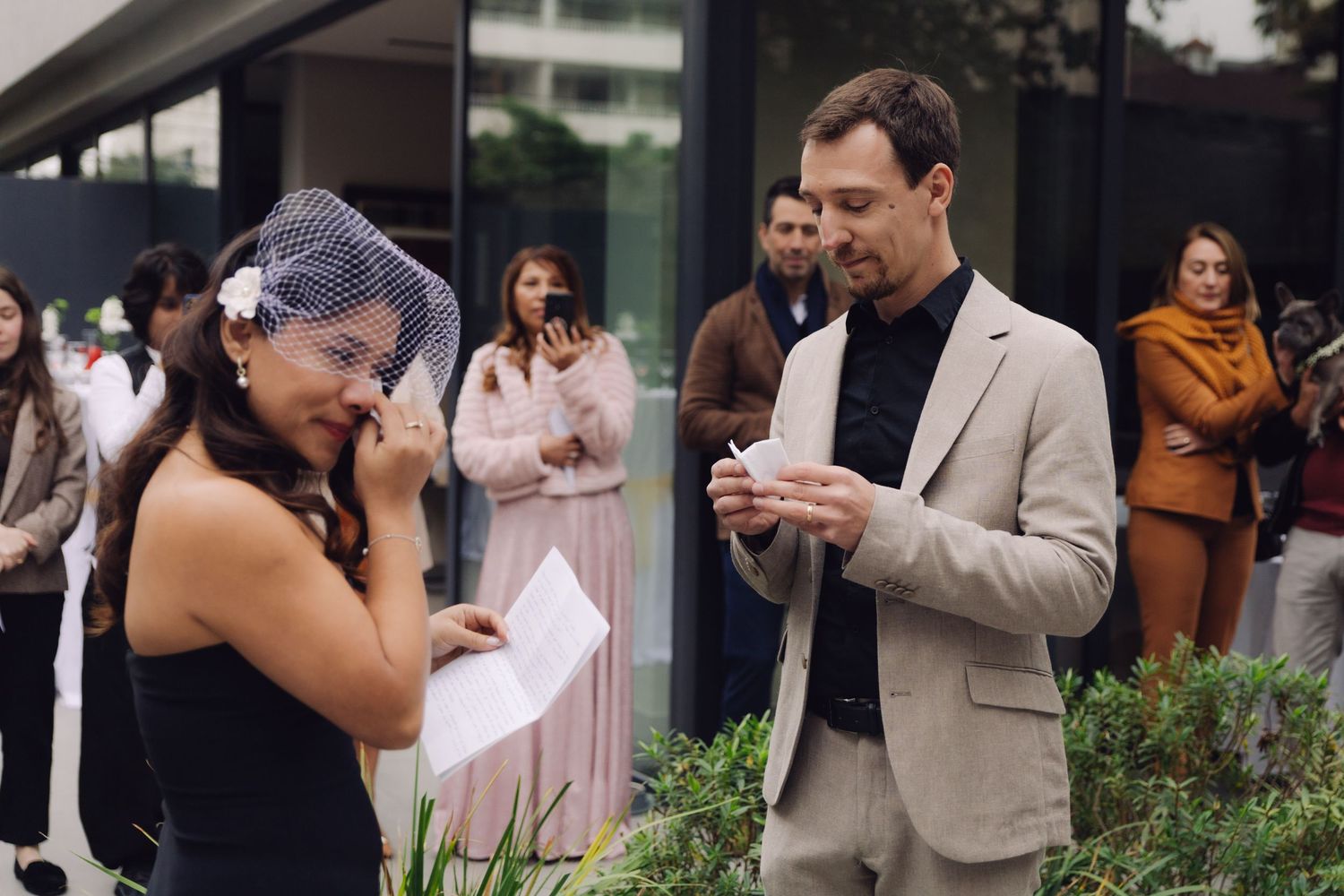 Bride and groom both emotional reading wedding vows at outdoor ceremony.