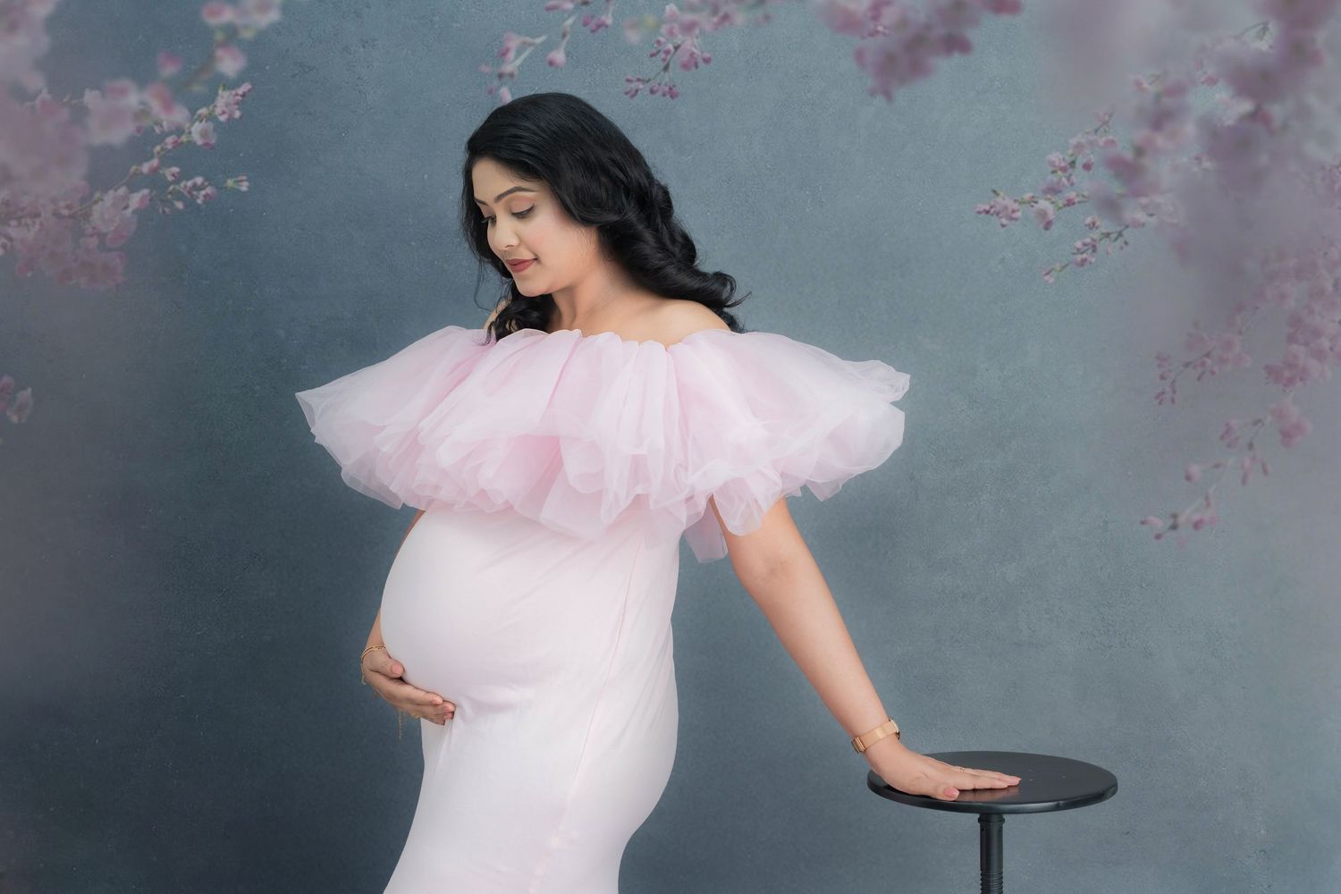 Soft studio maternity photoshoot of an expecting mother in a pink gown in Hyderabad