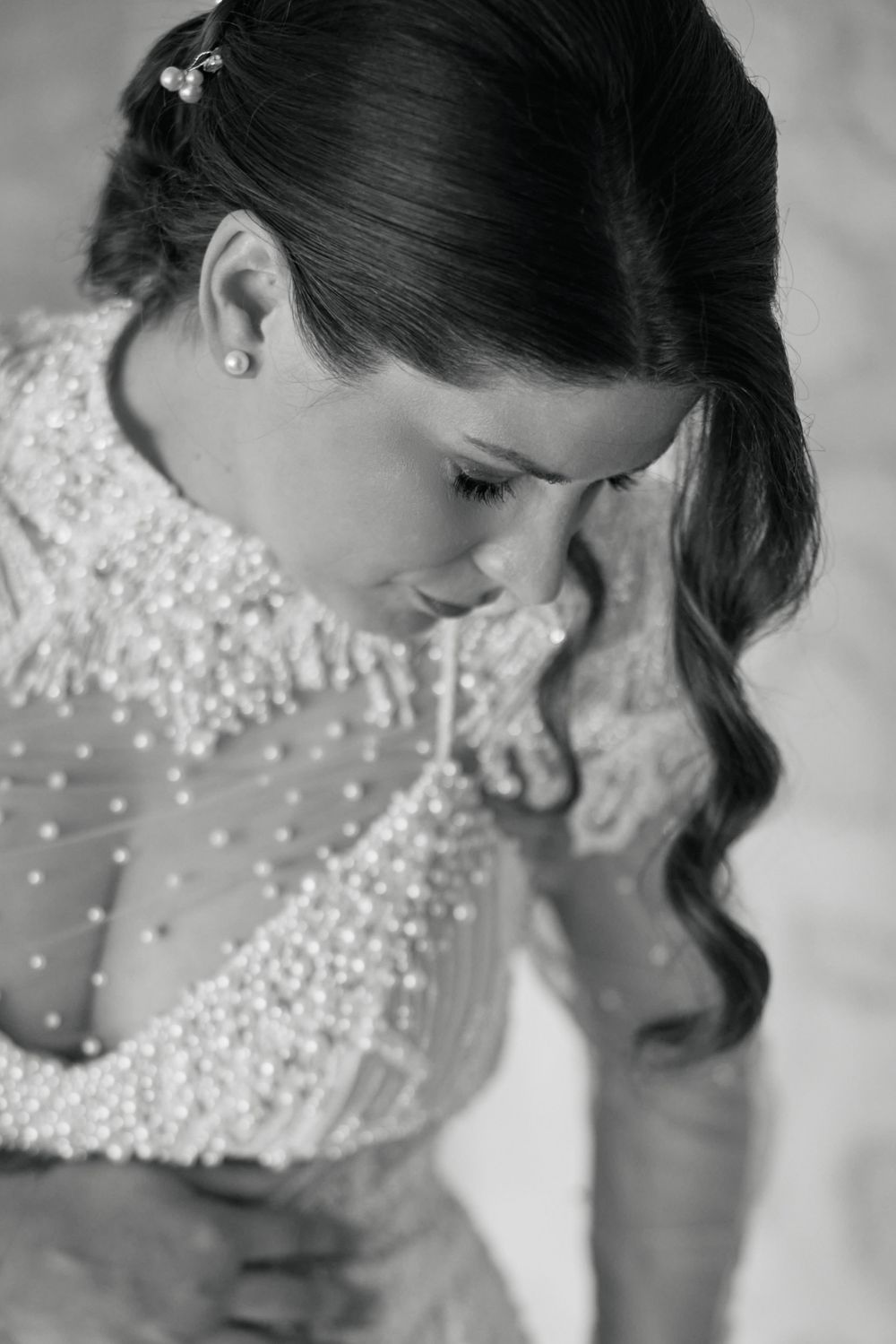 Close-up black and white portrait showing intricate beading details on a bridal gown.