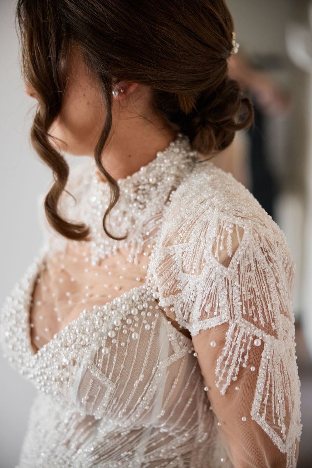 Detailed close-up shots of an elegant beaded wedding dress shoulder with delicate pearl embellishments.