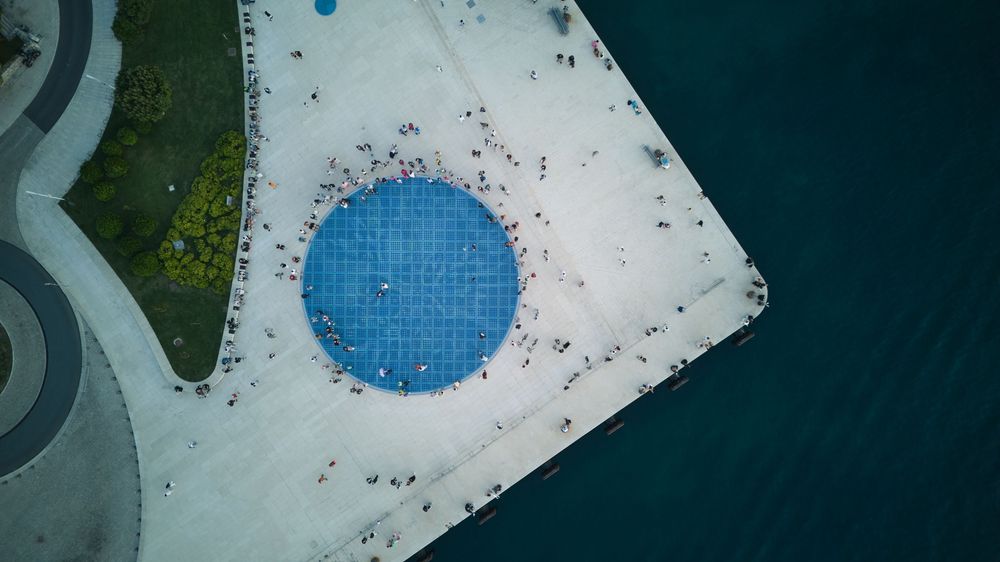 Aerial view of a white triangular shape with a bright blue circular feature in the center.