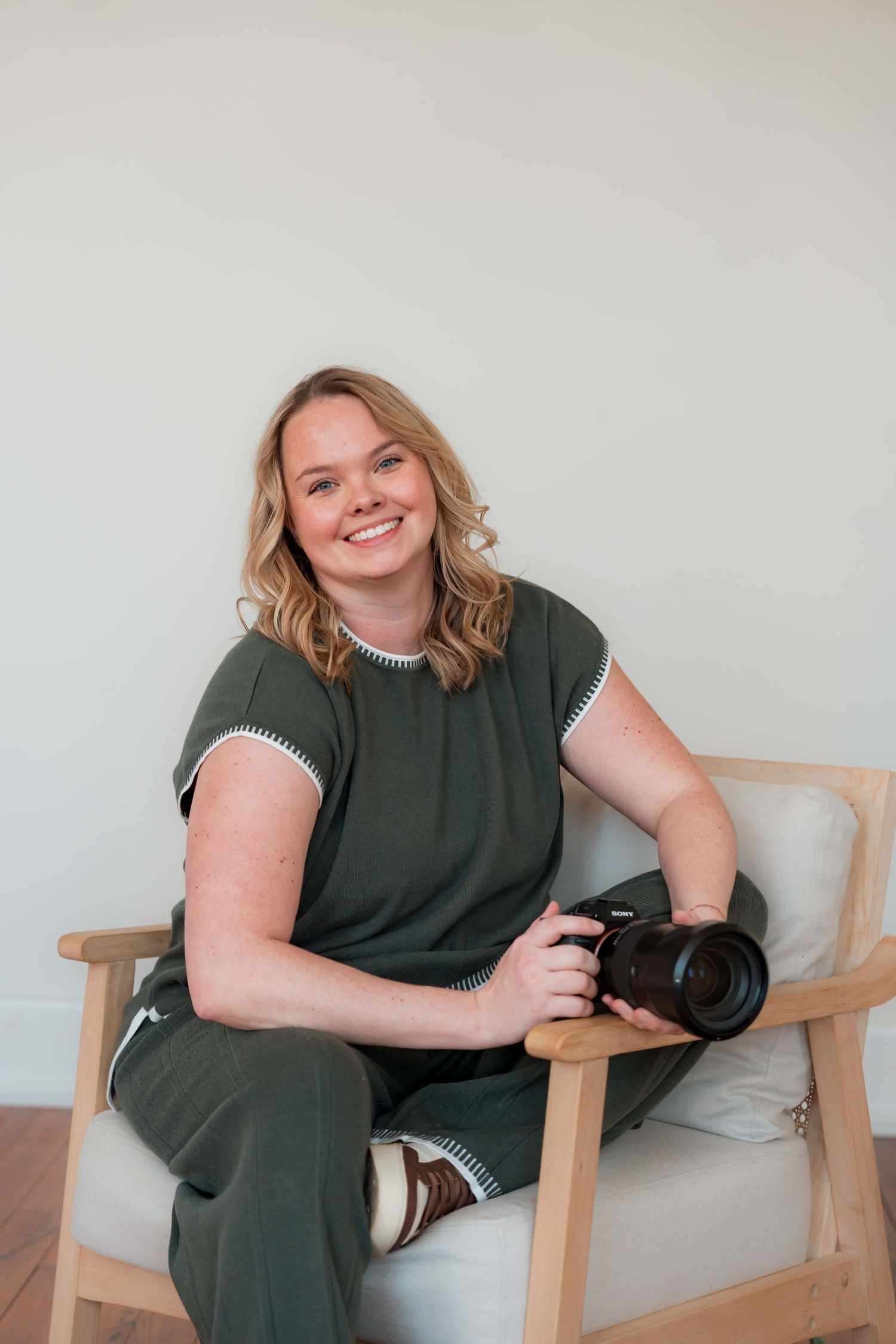 Person in olive green sleeveless top laughs while holding camera in split panel composition.
