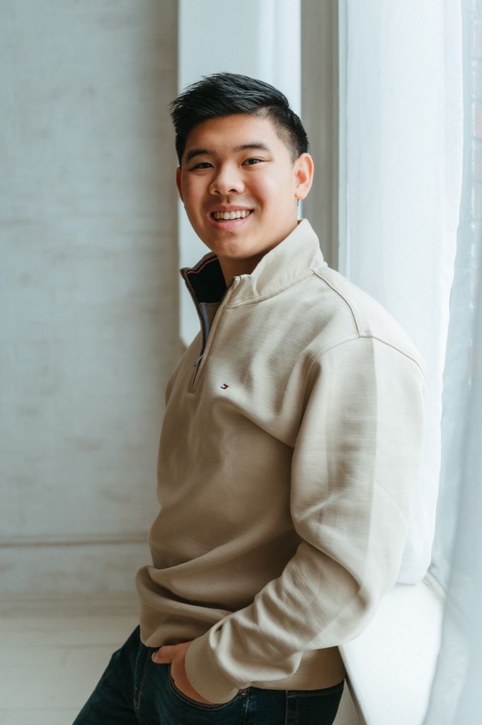 Fashion portrait series against white wall showing casual beige sweater and jeans styling.