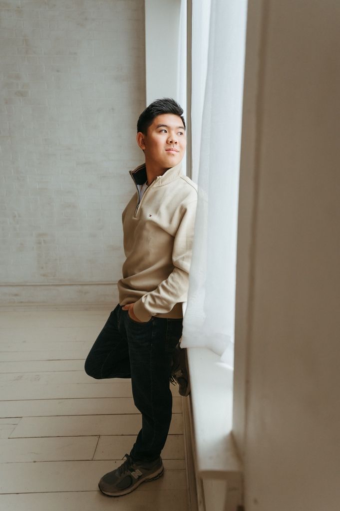 A series of artistic portraits showing a person in a beige sweater against a white wall in different poses.