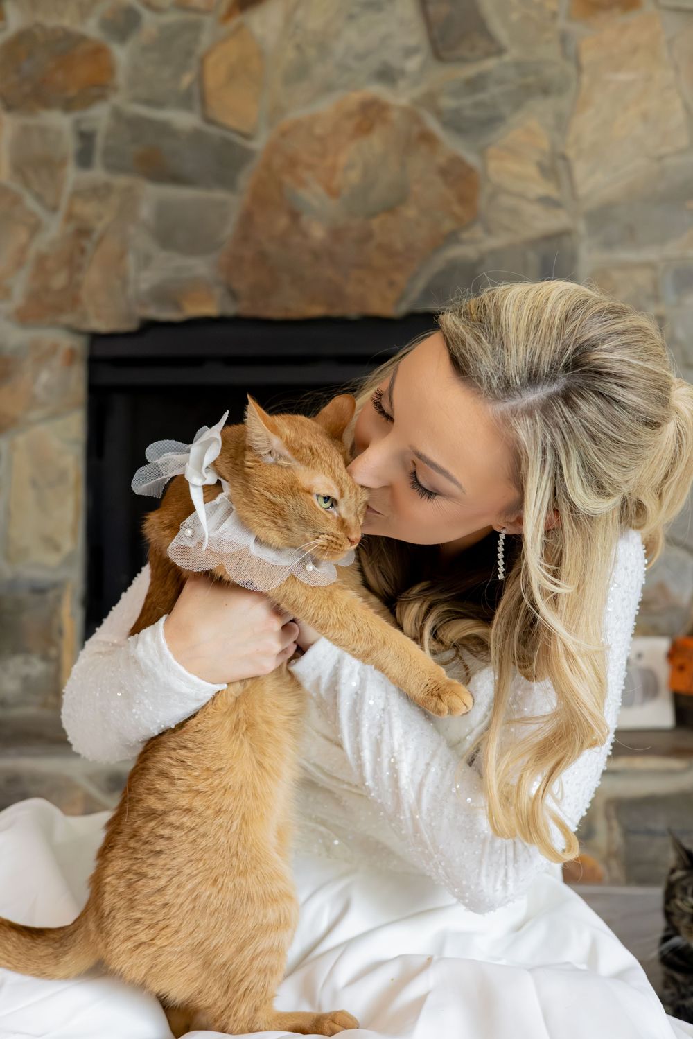 A sweet moment between a ginger cat and someone in white clothing showing affection and bonding.