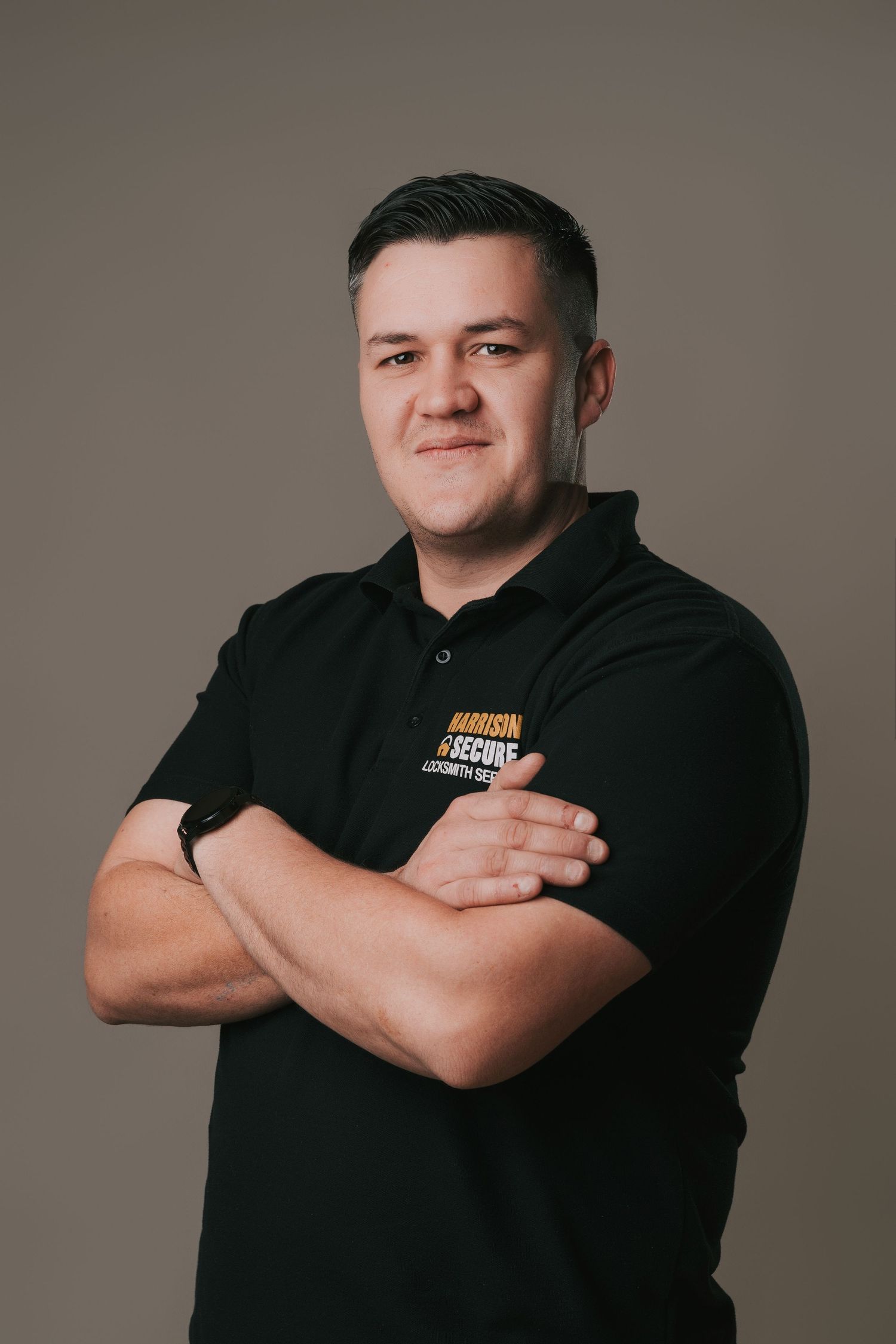 Professional studio portraits showing someone in a black polo shirt posing against a neutral gray background.