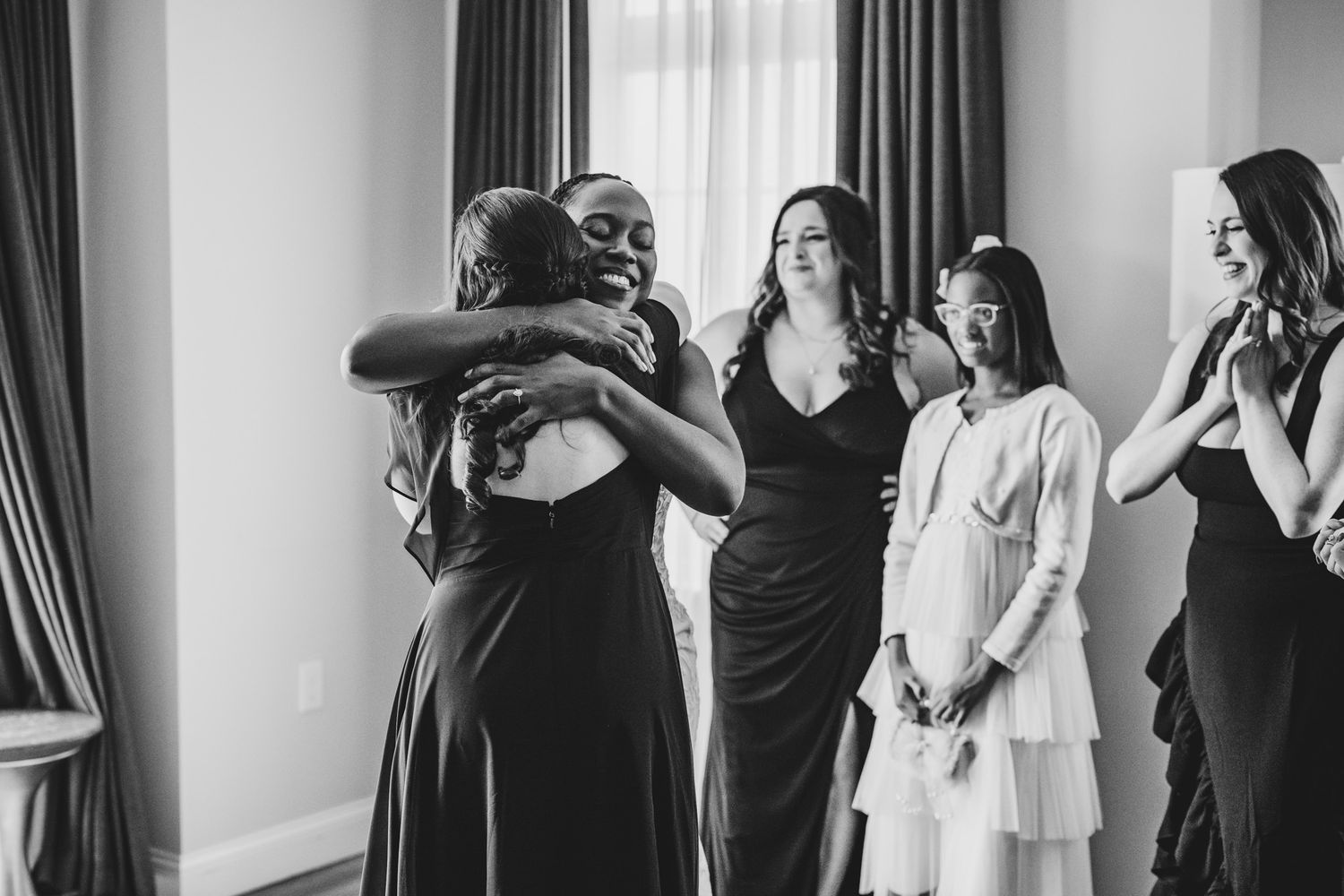 Group getting ready in hotel room with white walls and dark curtains.