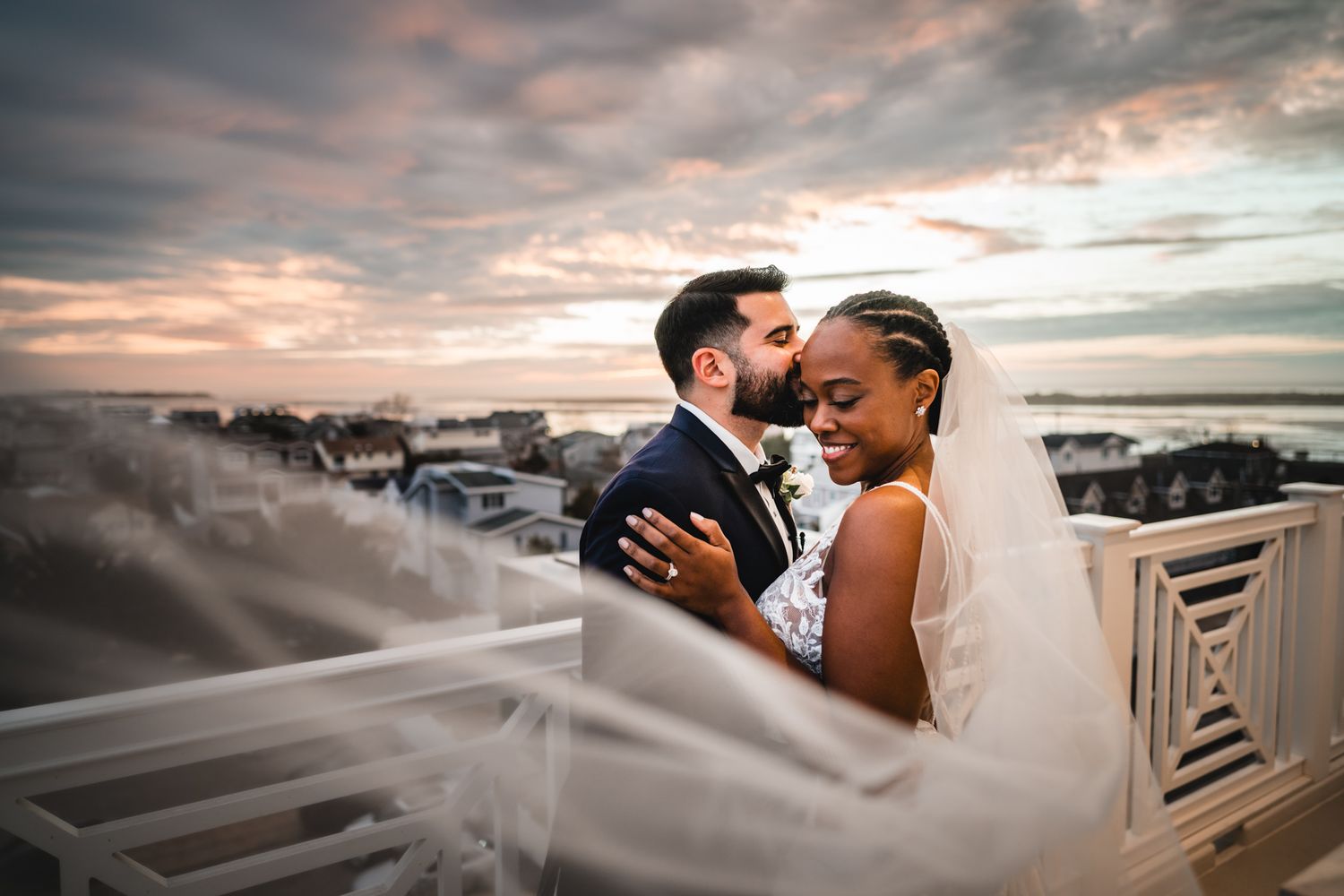Romantic sunset portrait on balcony with dramatic cloudy sky background.