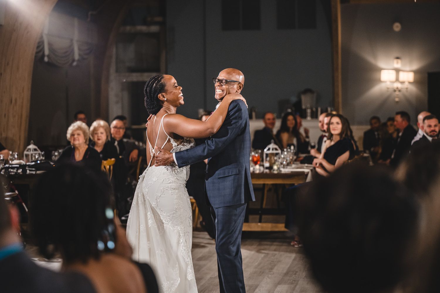 Couples dancing together during an evening wedding reception in a dimly lit ballroom.
