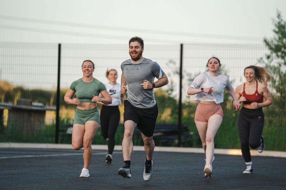 Athletes running together on an outdoor track during a group training session.