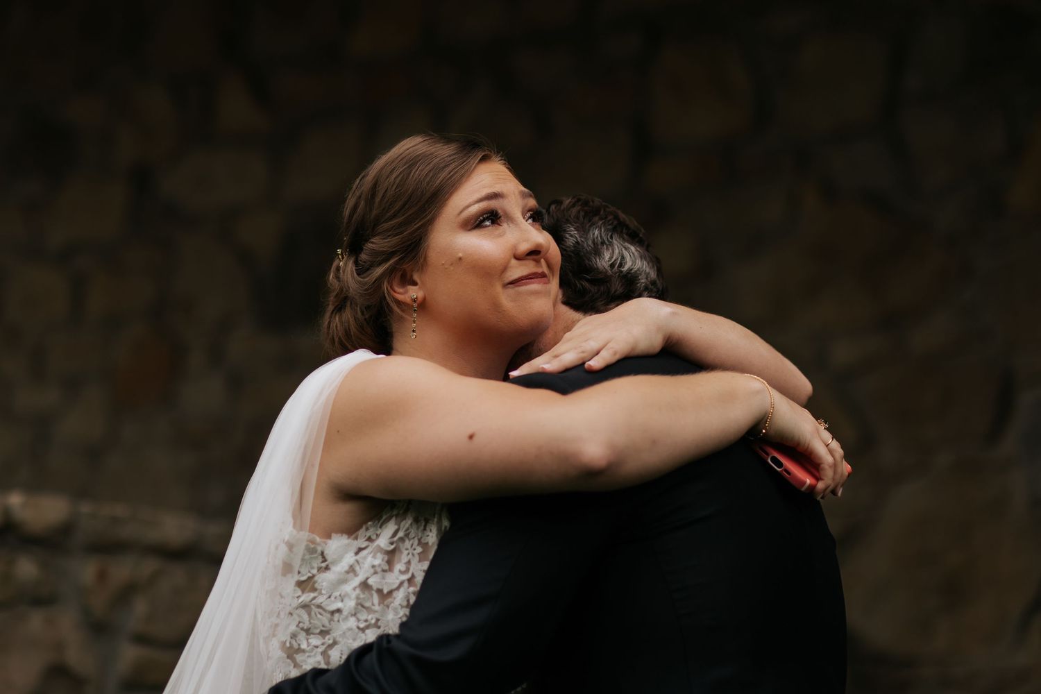 A couple embraces during their wedding photoshoot in a dark, moody outdoor setting. Conner Prairie, Fishers Indiana