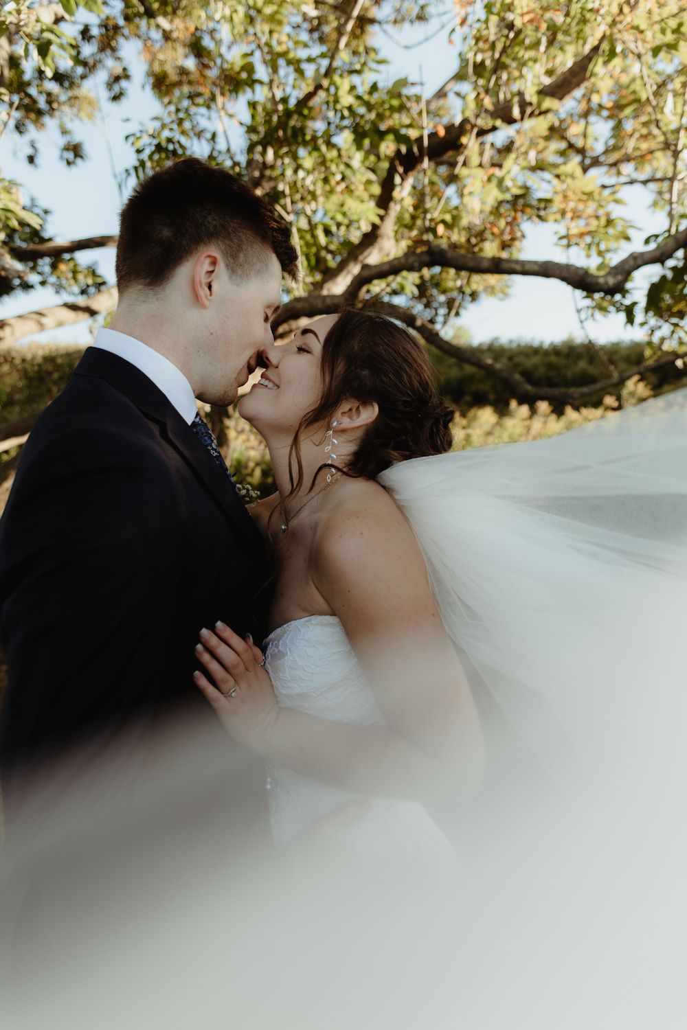 Absolutely stunning bride and groom veil shot that is personal and raw.