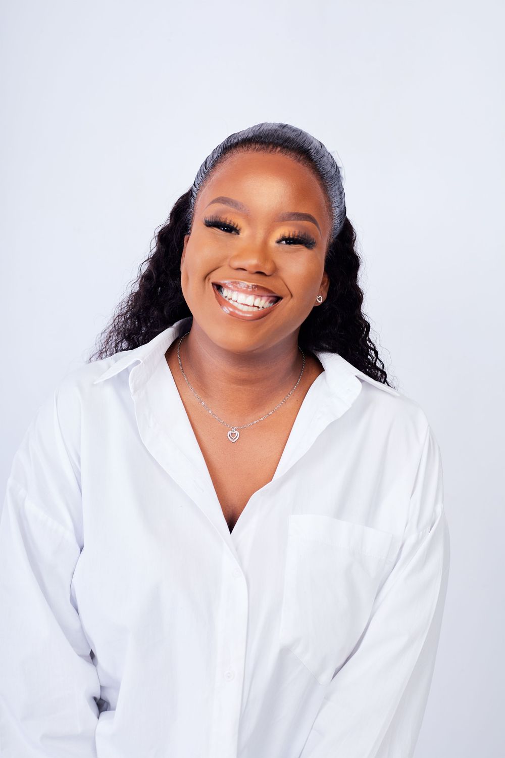 Professional portrait of someone wearing a crisp white button-down shirt against a light background.