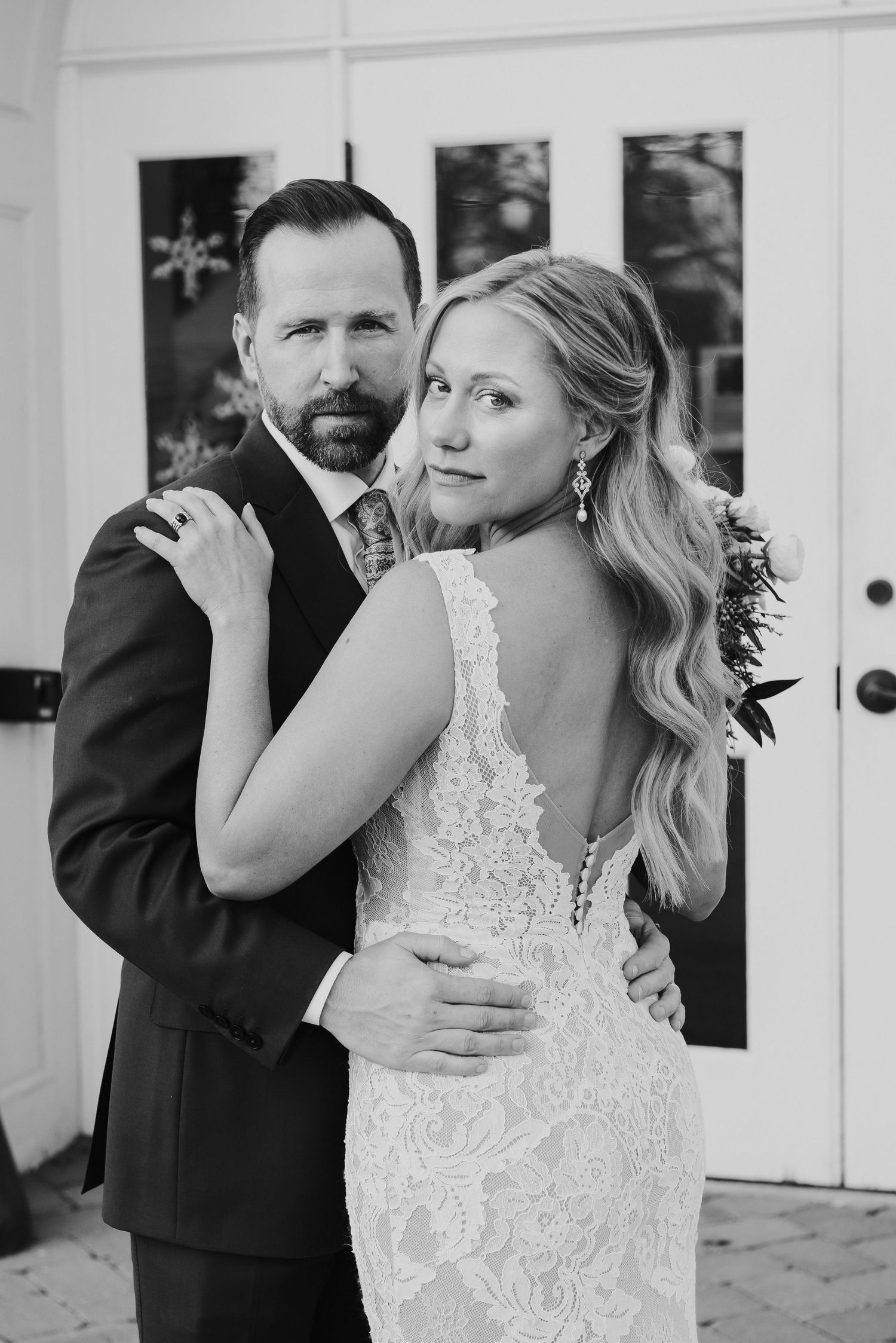 Black and white intimate portrait of couple in formal wedding attire.