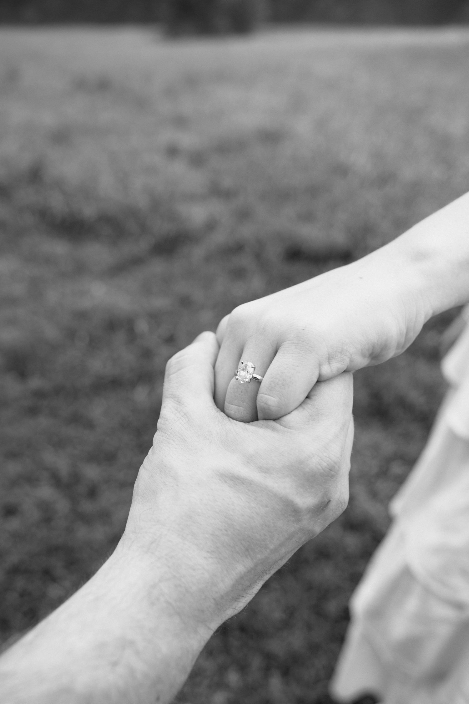 A series of black and white photographs showing close-up shots of hands holding each other with an engagement ring visible.