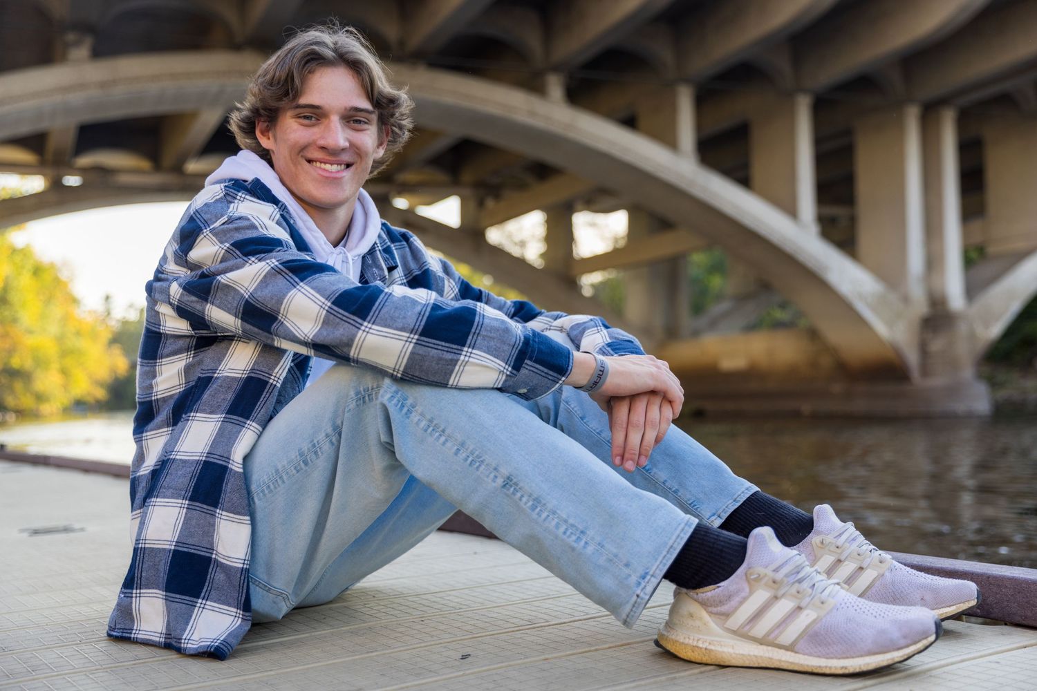 portrait of young man sitting on a dock