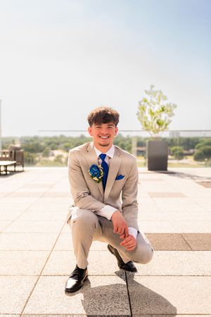 Young man in gray suit with blue tie and boutonniere prom photos at Arlington Texas Live Hotel. Dallas Fort Worth photographer