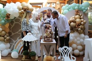 Family celebration with teddy bear themed balloon arch and decorations.