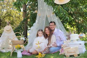 Picnic style outdoor celebration with white tent and tea party decorations.