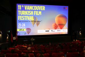 Movie theater screen displaying "11th Vancouver Turkish Film Festival" logo with hot air balloon graphics against dark auditorium.