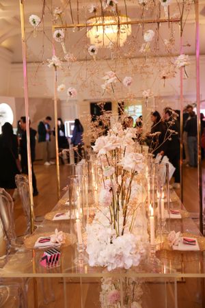 Enchanting wedding reception decor with hanging floral arrangements and glass vases.